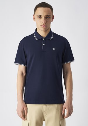Polo shirt blu navy con colletto bianco e strisce sulle maniche, realizzato in tessuto morbido. Presenta due bottoni sul collo e un piccolo logo sul petto.