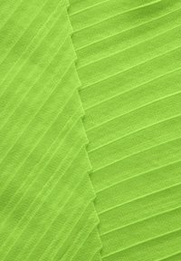 Tissu vert vif avec une texture côtelée et des plis diagonaux, mettant en valeur un matériau doux et léger. Pas de motifs visibles ni de détails matériels.