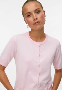 Kortärmad rosa kofta i mjukt stickat tyg, med hjärtformade knappar längs fram och rund halsringning.