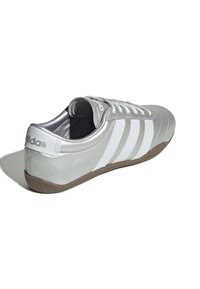 Sneaker sintetico argento con strisce bianche, design con lacci, collo imbottito e suola in gomma testurizzata, con logo sul tallone.