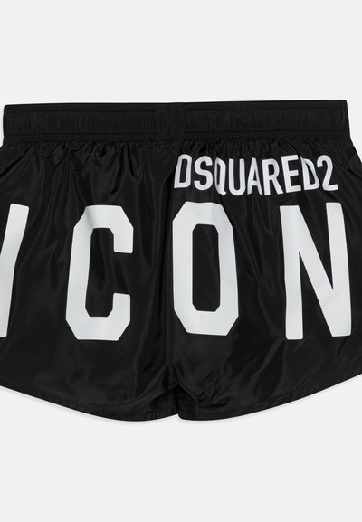 Pantalones cortos negros hechos de una tela suave, con grandes letras impresas en blanco "ICON" y "DSQUARED2" en la parte trasera, en una tipografía moderna y audaz.