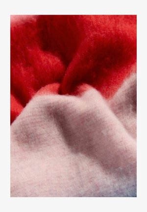 Tekstūruota vilnos audinys, kuriame dera raudonos ir švelniai rožinės spalvos tonai. Spalvos sklandžiai susilieja, pabrėždamos minkštą, pūkuotą tekstūrą.