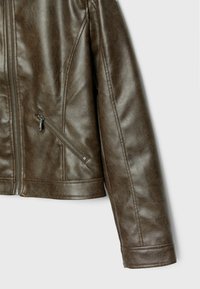 Bruine leren jas met een ritszak, een gladde textuur en een gestructureerde pasvorm. De jas heeft een klassieke kraag en subtiele stikseldetails.