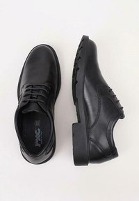 Chaussures noires en cuir avec une finition lisse, un laçage, un bout rond et une semelle en caoutchouc texturée pour une adhérence optimale.