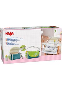 Diaper changing bag in teal and green fabric featuring a decorative flower pattern, shoulder strap, and side pockets with bottles.