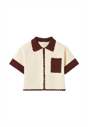 Chemisette courte à manches courtes avec un corps crème, un col en tricot marron et une poche. Comprend des bords festonnés et des motifs texturés sur le col.