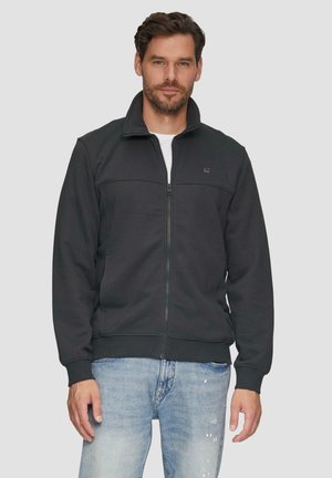 Black zip-up jacket in soft fabric, featuring a high collar, ribbed cuffs and hem, with a smooth texture and minimal logo detail.