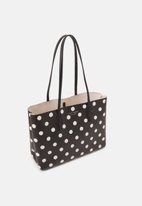 Borsa a spalla nera con pois bianchi, maniglie doppie, superficie liscia, apertura superiore e ampio interno. Presenta il branding all'interno.