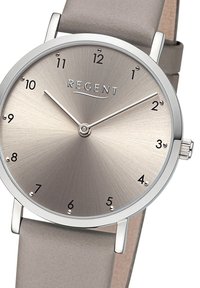 Montre ronde en argent avec un cadran gris métallique brossé, marquages horaires noirs minimaux et un bracelet en cuir gris doux. Nom de la marque "REGENT" affiché.