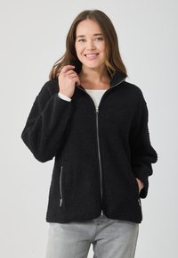 Μαύρο φούτερ μπουφάν με ψηλό γιακά, φερμουάρ μπροστά και δύο πλαϊνές τσέπες. Διαθέτει μαλακή, υφασμάτινη επιφάνεια και άνετη εφαρμογή.