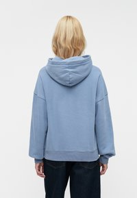Felpa con cappuccio blu dal fit rilassato, dotata di tasca a marsupio e polsini a coste. Tessuto morbido e di peso medio.