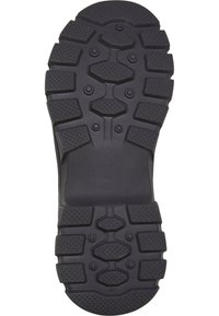 Semelle de chaussure en caoutchouc noir avec un profil profond et des motifs texturés ; présente des éléments de prise hexagonaux et circulaires pour une meilleure traction.