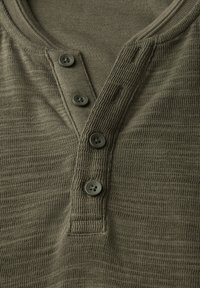 Olivgrön strukturerad henleytröja med treknappars placket och ribbat nacke, med fina horisontella ränder överallt.