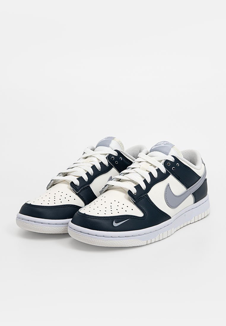 Le sneakers Nike Dunk presentano una tomaia in pelle blu navy e bianca, con una punta perforata, linguetta imbottita e suola in gomma.