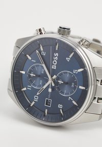 Orologio cronografo in acciaio inossidabile argentato con quadrante blu scuro, dotato di indici ore bianchi, finestra della data e sottodial.
