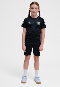 Uniforme de sport noir composé d'un maillot à manches courtes et d'un short, avec un logo vert et violet et le numéro 12 sur le devant.