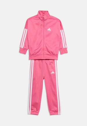 Chándal rosa de dos piezas con rayas blancas en las mangas y los pantalones, con chaqueta con cremallera y puños y cintura elásticos.