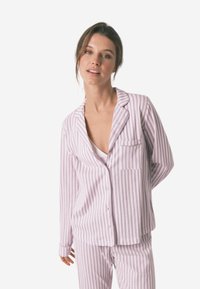 Gestreepte pyjama set in lichtpaars en wit, gemaakt van zachte stof. Beschikt over een knoopsluiting aan de bovenkant met pocket en een bijpassende broek.