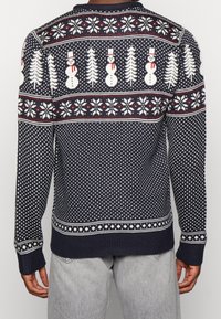 Maglione navy con motivi di pupazzi di neve e fiocchi di neve bianchi, rossi e crema. Polsini e bordo a coste. Tessuto lavorato a maglia, design a collo rotondo.