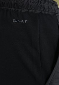 Mustat Dri-FIT-shortsit, joissa on joustava vyötärö, sileä kangas ja huomaamaton logoyksityiskohta. Kevyt muotoilu, sopii aktiiviseen käyttöön.