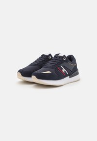 Navy blue athletic sneakers with a suede upper, rubber sole, round toe, lace-up design, and accented with red and gold detailing.
