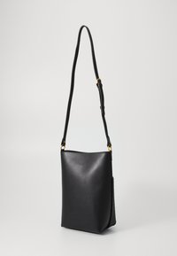 Saco de couro preto em forma de balde com textura suave, alça ajustável, detalhes em metal dourado e um bolso lateral em malha para armazenamento adicional.