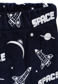 Navy blue pajama pants in soft fabric; features white printed space motifs including spaceships, moons, and stars. Elastic waistband.