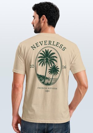 Man with dark hair and beard wearing beige t-shirt with palm trees and sailing boat graphic labeled "NEVERLESS 2016 French Riviera."