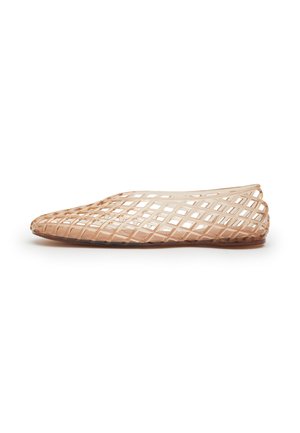 Singola scarpa piatta beige con design a reticolo aperto e punta arrotondata, mostrata di profilo su sfondo bianco.