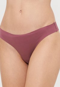 Mauve bikini slipjes gemaakt van zacht materiaal met een naadloos ontwerp en een dunne tailleband, wat zorgt voor een minimalistische en comfortabele pasvorm.