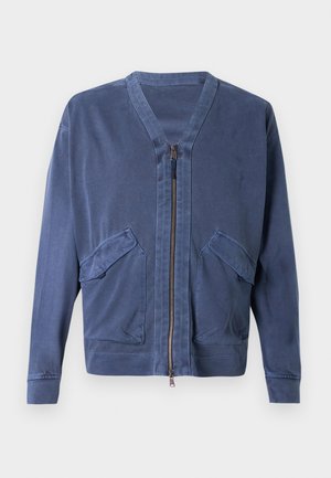 Μπουφάν με φερμουάρ σε ναυτικό μπλε χρώμα, με V-λαιμόκοψη, δύο μπροστινές τσέπες και ομαλή υφή. Διαθέτει μακριά μανίκια και εφαρμοστή σχεδίαση.