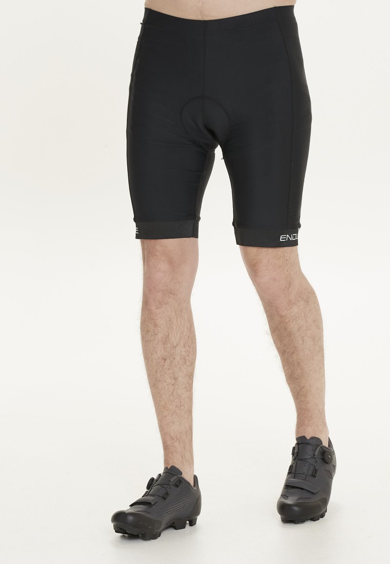 Pantalones cortos de ciclismo negros hechos de material elástico, con un asiento acolchado integrado. El diseño se ajusta al cuerpo con costuras planas y un logo.