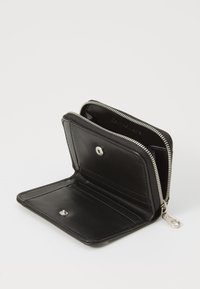 Portafoglio in pelle nera con chiusura a zip, dotato di molteplici scomparti per carte e un dettaglio con bottone a pressione. Texture liscia e design compatto.