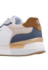 Sneaker bianco con tallone in suede marrone chiaro e dettagli blu navy. Presenta una forma arrotondata, tessuto texturizzato e suola in gomma con particolare logo.