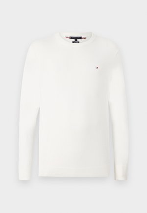 Suéter branco de malha com mangas longas e decote redondo. Apresenta um pequeno logótipo em vermelho, branco e azul no lado esquerdo do peito. Textura suave.