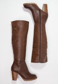 Botas marrones hasta la rodilla, hechas de cuero texturizado, con tacón cuadrado, cremallera lateral y detalle de hebilla en la parte superior.
