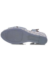 Blue patterned sandal with woven upper, flat textured sole, and brown leather accents. Size 38, made in Spain, featuring a secure strap design.