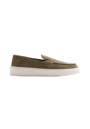 Zapato de ante verde oliva tipo slip-on con suela de goma blanca, perfil bajo y costuras estilo mocasín a lo largo del borde superior.