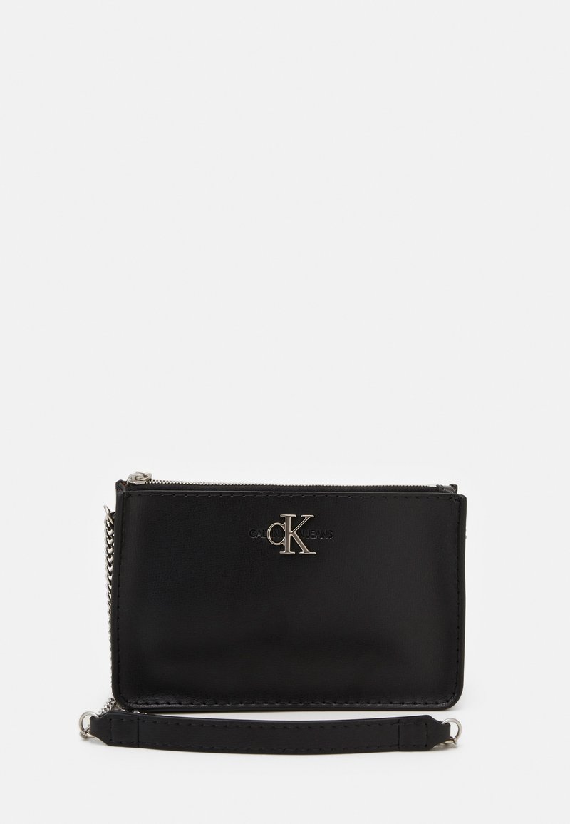 Portafoglio in pelle nera con chiusura a zip, dotato di logo argentato e tracolla a catena. Texture liscia, forma rettangolare, design minimalista.