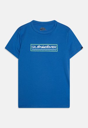 T-shirt en coton bleu avec un col rond. Présente un graphique rectangulaire blanc avec des accents verts et une bordure à carreaux. Manches courtes.