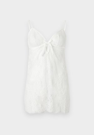 Robe nuisette en dentelle blanche avec fines bretelles réglables, encolure en V, découpe en trou de serrure à l'avant et motif en dentelle florale sur toute la robe.