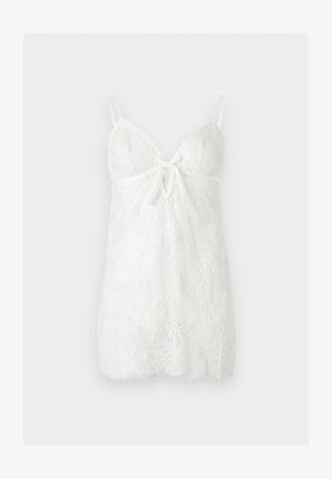 Λευκό φόρεμα από δαντέλα με λεπτές ρυθμιζόμενες τιράντες, V-λαιμόκοψη, άνοιγμα μπροστά σε σχήμα κλειδαρότρυπας και φλοράλ σχέδιο δαντέλας σε όλο το φόρεμα.