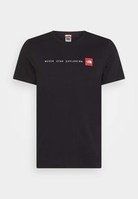 Camiseta negra de manga corta con cuello redondo, con el texto blanco "NUNCA DEJES DE EXPLORAR" y un logo rojo de The North Face en el pecho.