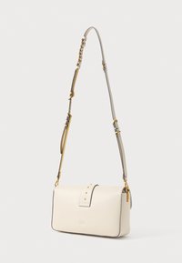 Krém színű bőrtáska ívelt formával, arany fém kiegészítőkkel és levehető pánttal. Jellemző rá a hajtogatós fedél, amelyet szegecsek díszítenek.