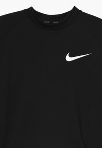 Felpa nera realizzata in tessuto morbido, con scollo rotondo e maniche raglan, con il logo Nike swoosh bianco sul petto.