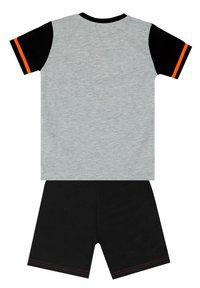 Grijze katoenen T-shirt met zwarte mouwen en een oranje streep, gecombineerd met zwarte shorts met rode stiksels langs de zoom.