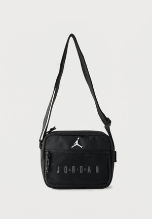 Bolso bandolera negro rectangular con correa ajustable, bolsillo frontal de malla, logo Jumpman blanco y texto "JORDAN" en el bolsillo.