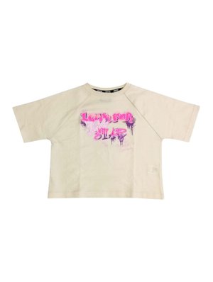 T-shirt corto a maniche corte color beige chiaro con una vestibilità oversize, caratterizzato da una grafica in stile graffiti rosa e viola sul davanti.
