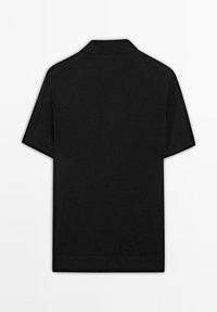 Polo shirt noir à manches courtes avec un col classique, une texture lisse et un design épuré et minimaliste sans logos ni motifs visibles.