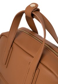 Bruine leren handtas met een gestructureerd oppervlak, gouden rits en twee handvatten aan de bovenkant. Heeft een rechthoekige vorm met minimalistische designelementen.